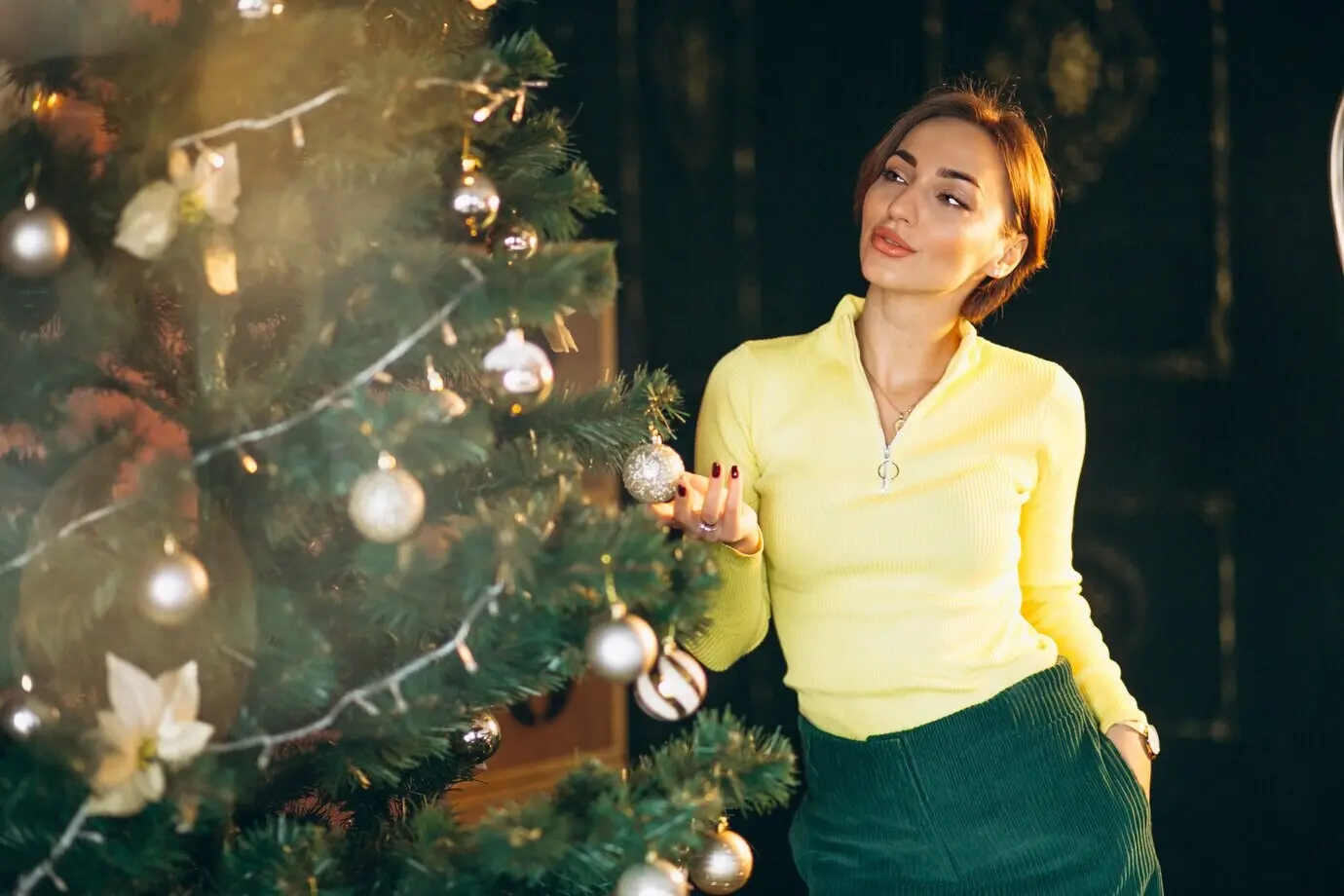 A woman is decorating a Christmas tree.