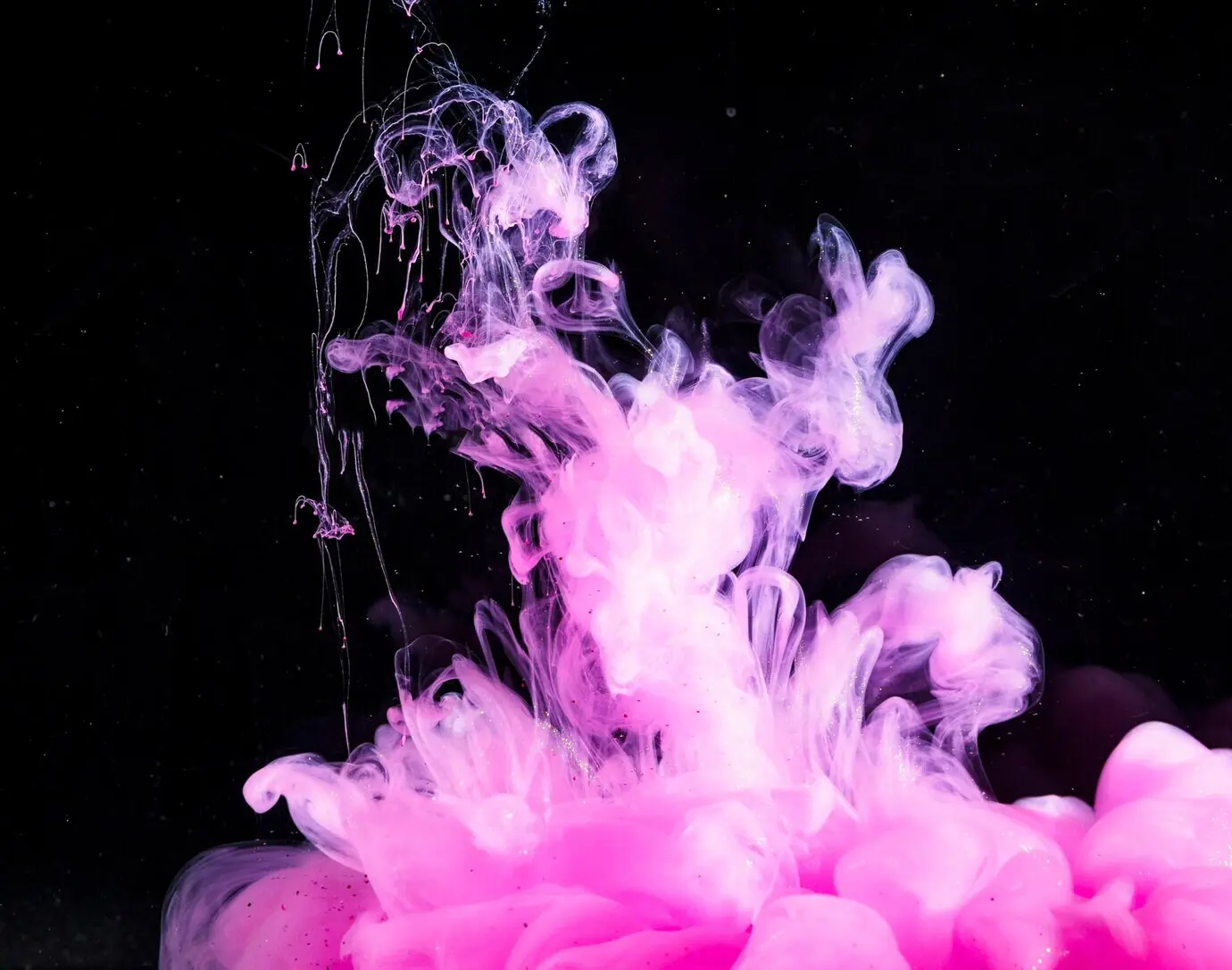 Abstract dense pink mist in a dark liquid